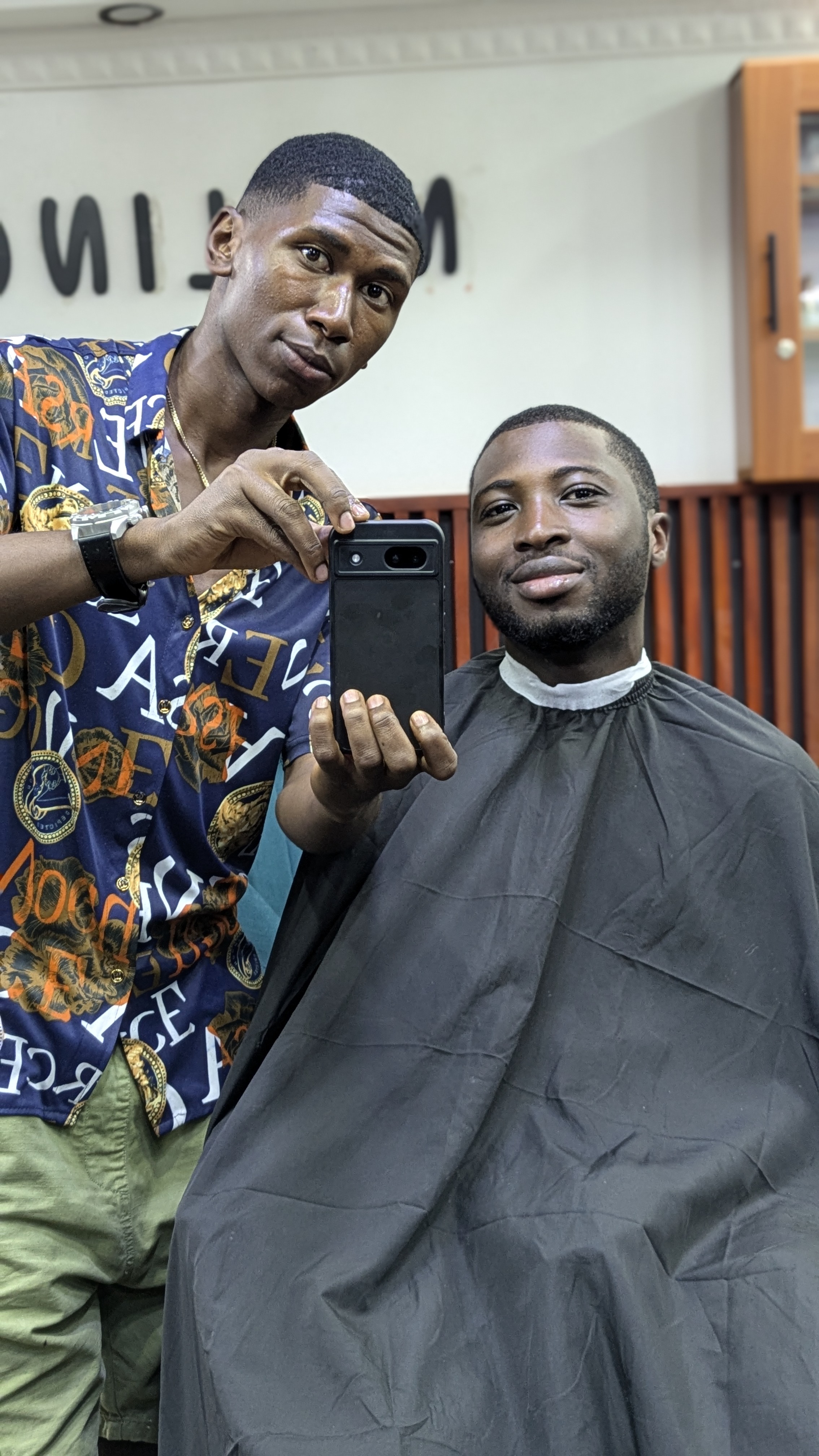 Danny taking a photo of Richard after his haircut